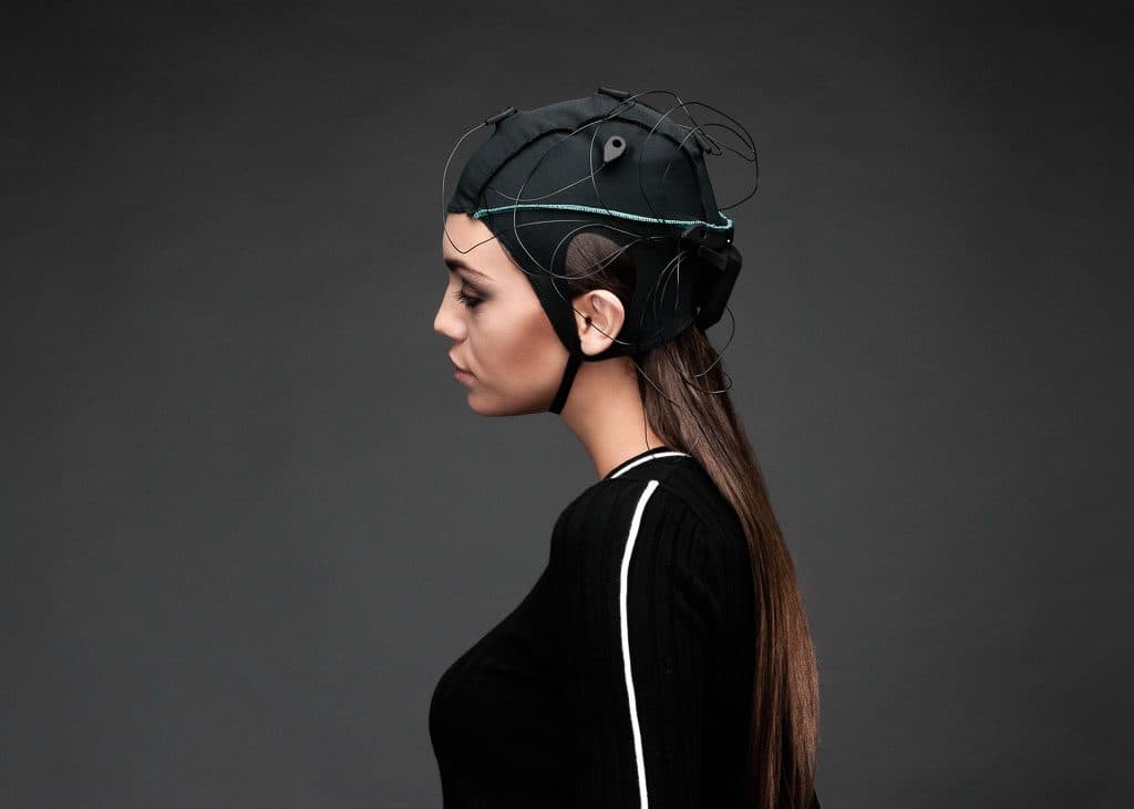 A woman wearing a Unicorn BCI Core-8 cap, in profile