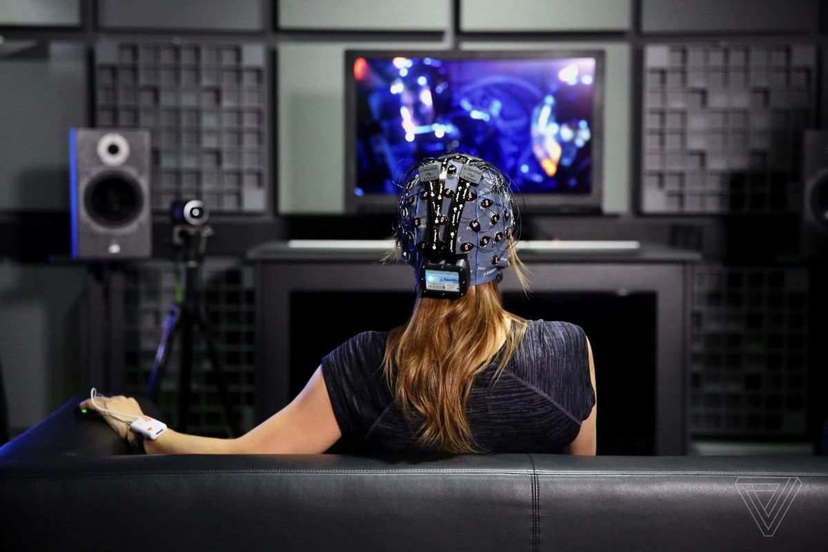 A participant wearing an EEG cap while watching audiovisual stimuli