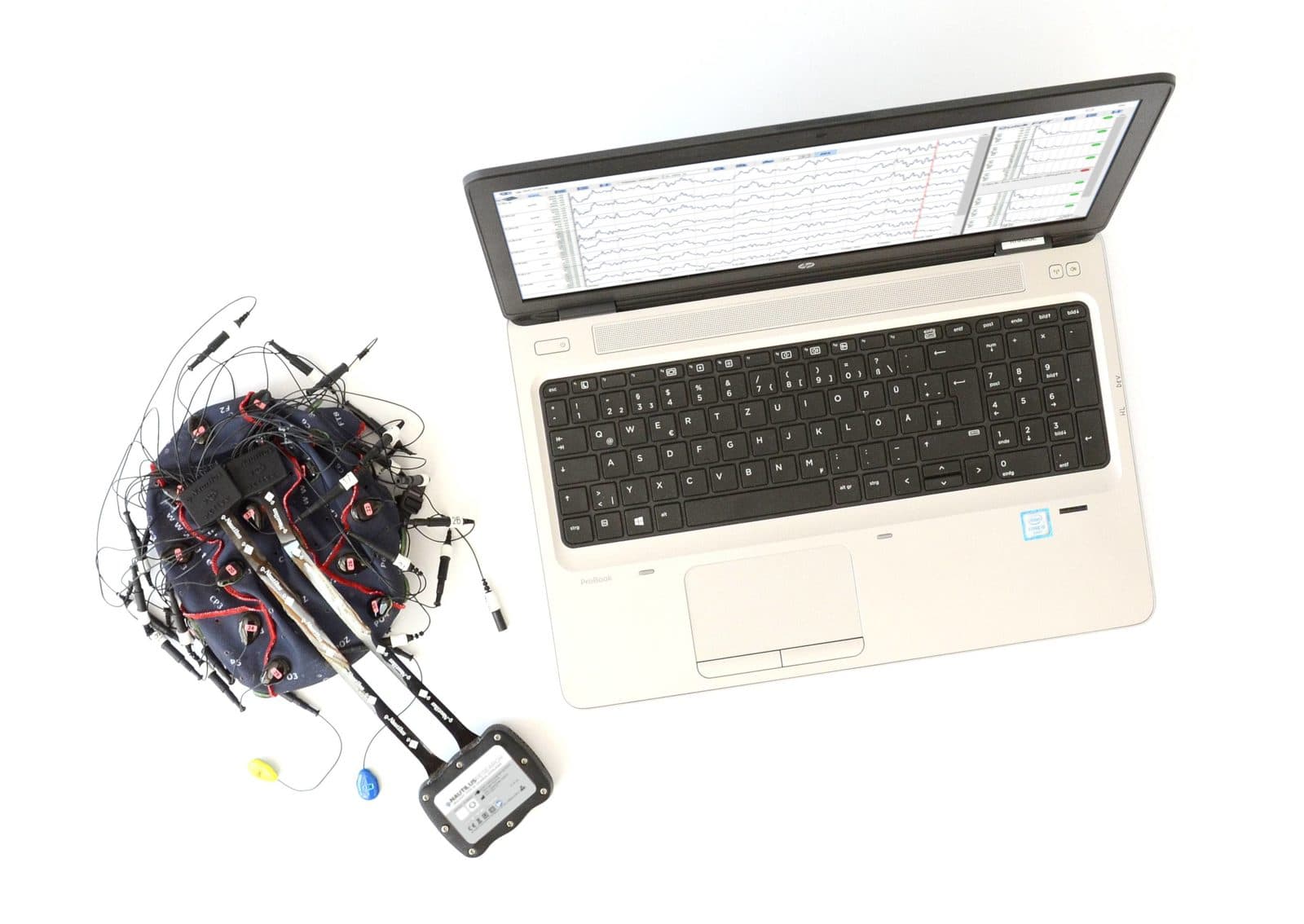 A g.Nautilus headset and a laptop showing an EEG recording