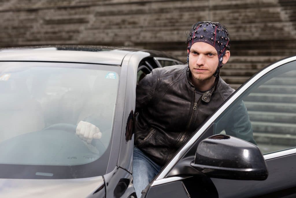 A participant with a g.Nautilus Research EEG cap stepping out of a car
