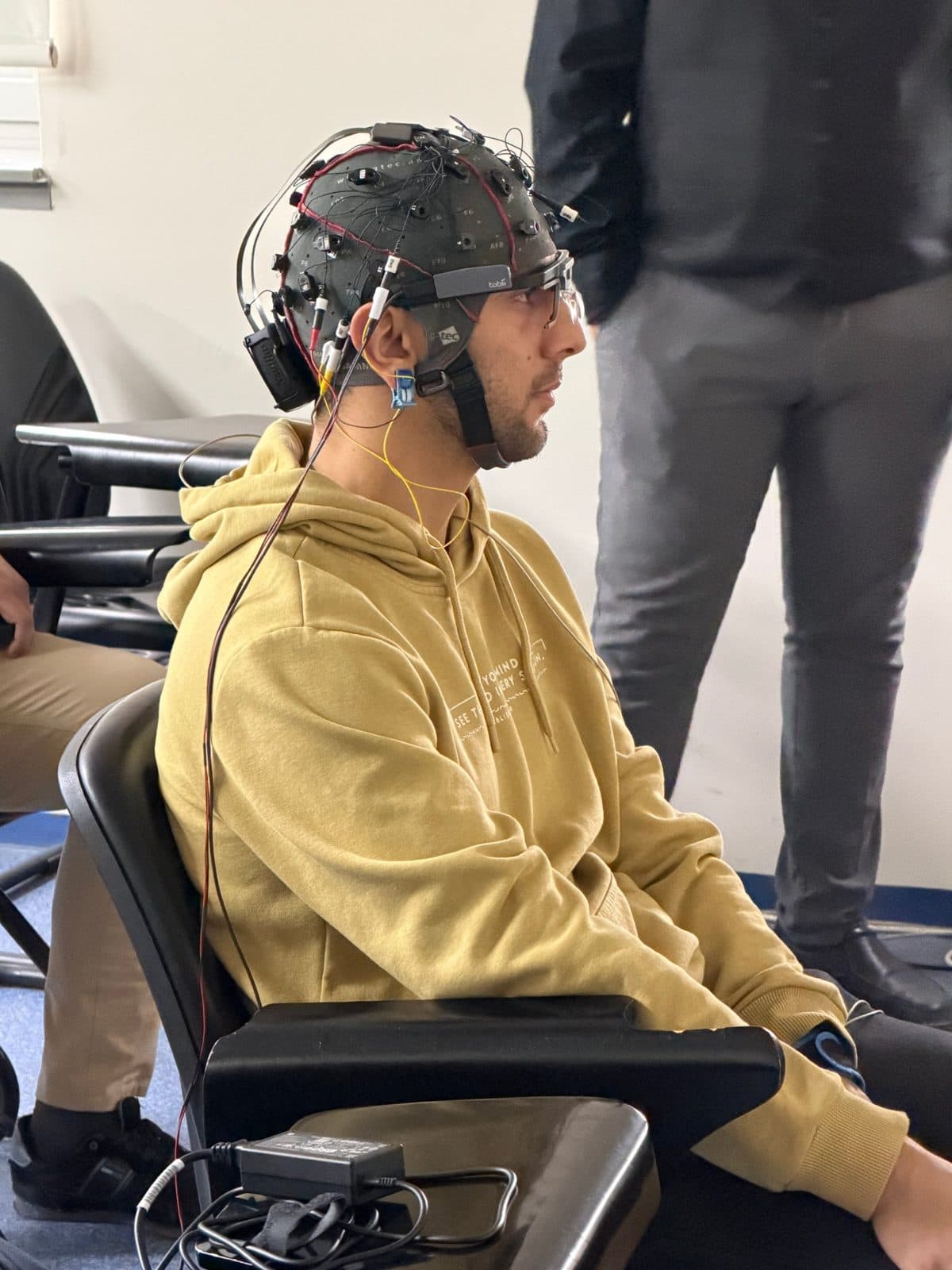 Profile of a participant wearing an EEG cap and eye-tracking glasses.