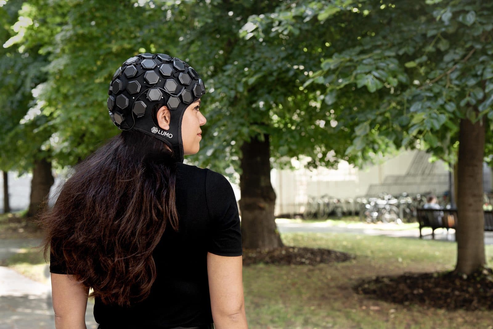 A researcher wearing a whole-head LUMO cap in a garden